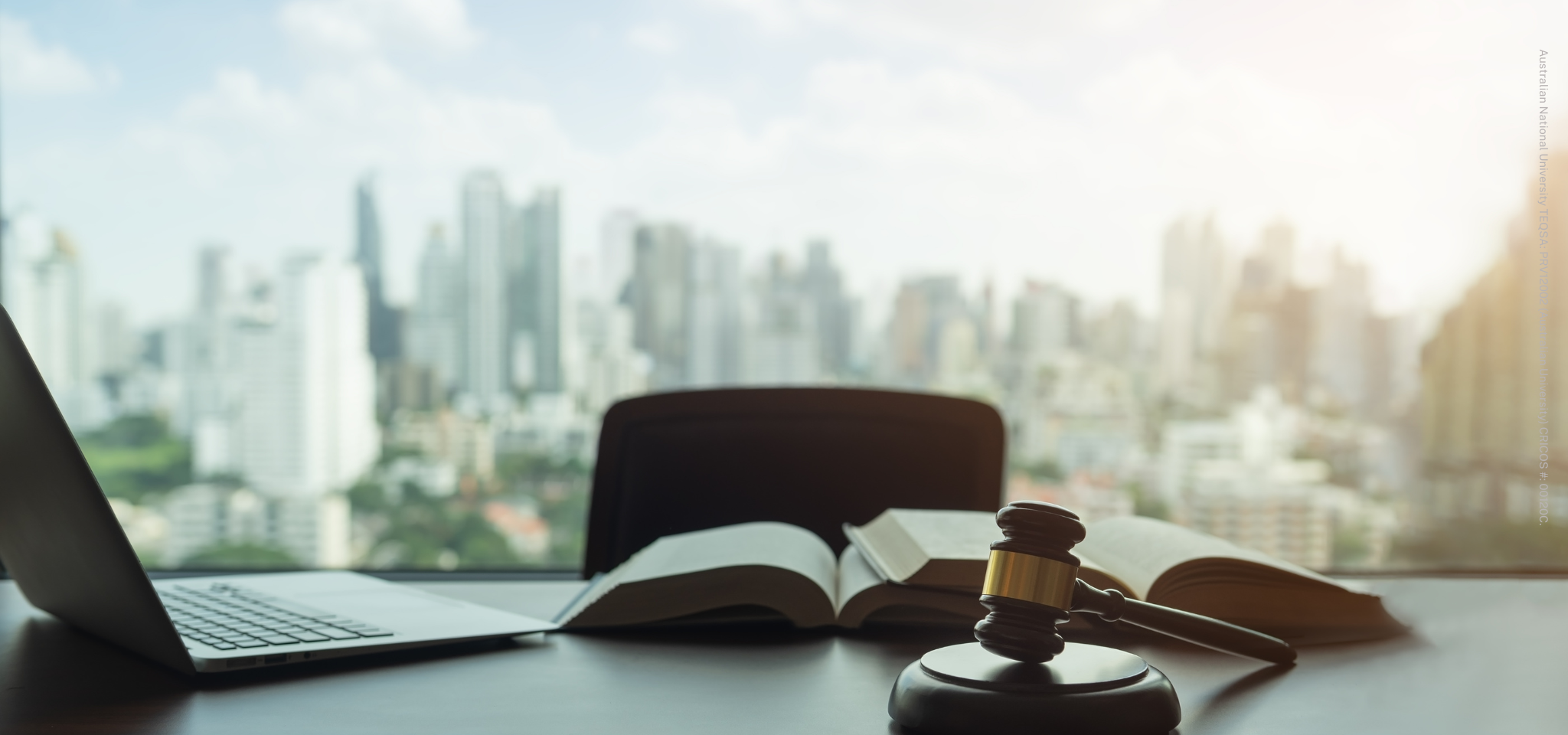 Desk with book and gavel, city in background window