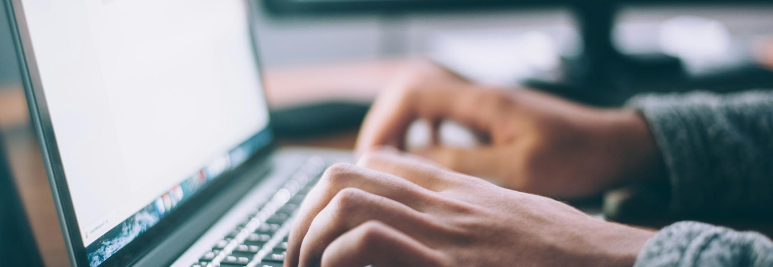Student typing on a laptop
