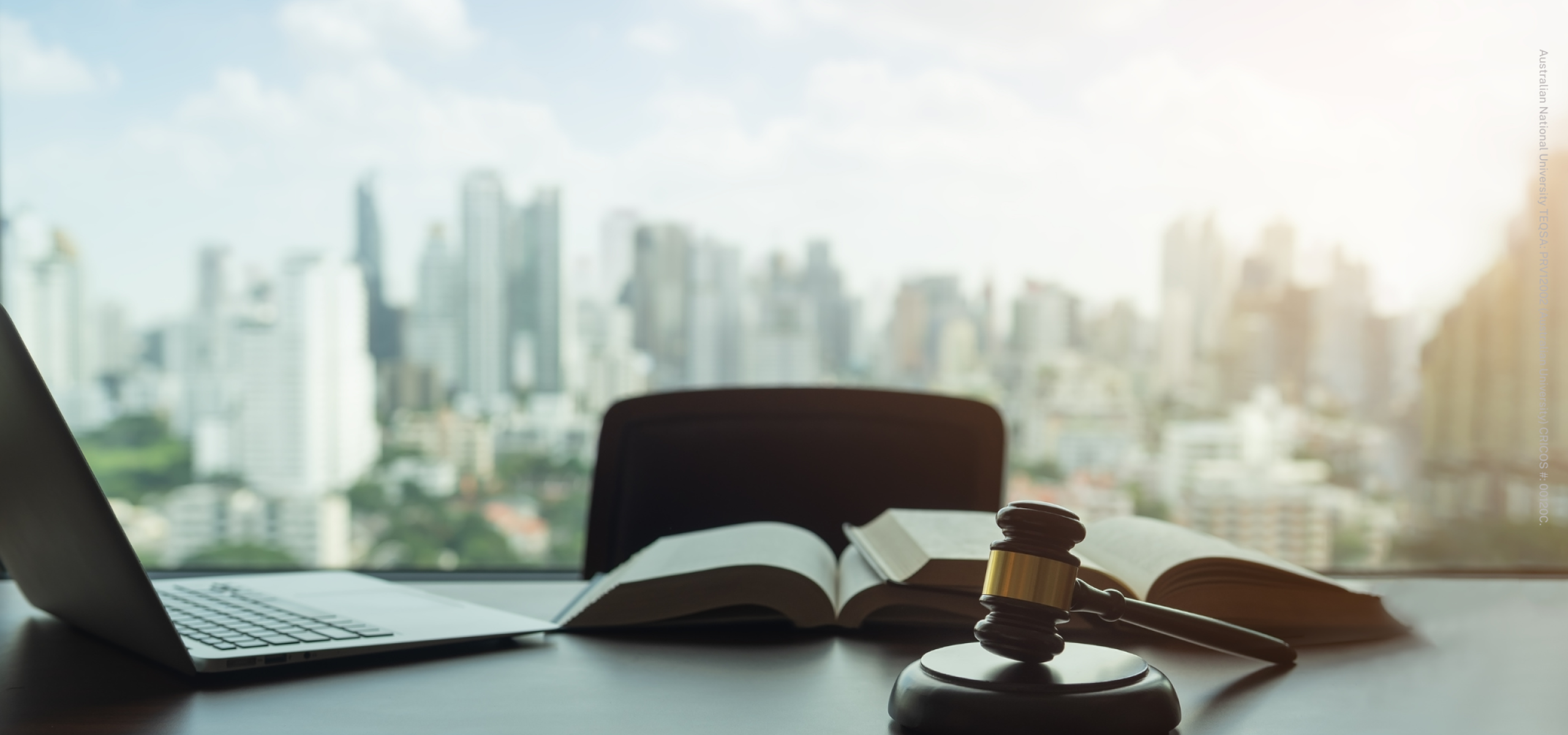Desk with book and gavel, city in background window
